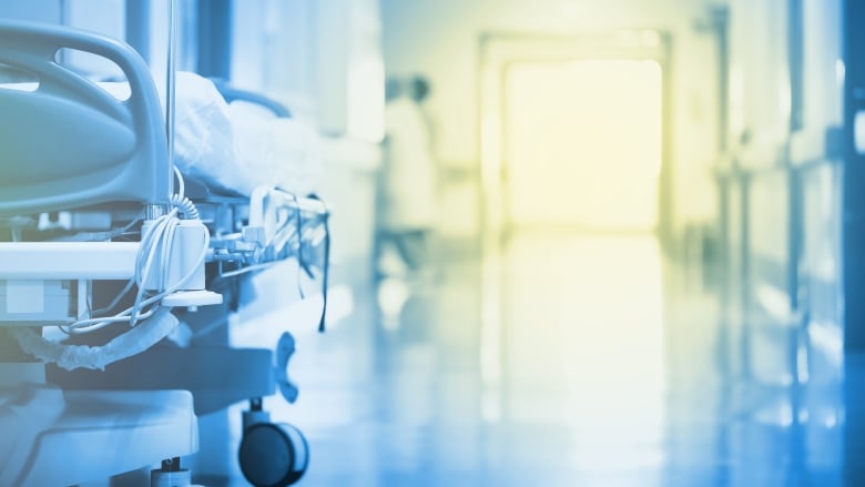 Mysterious, enchanting light in a hospital hallway with a bed in the foreground.