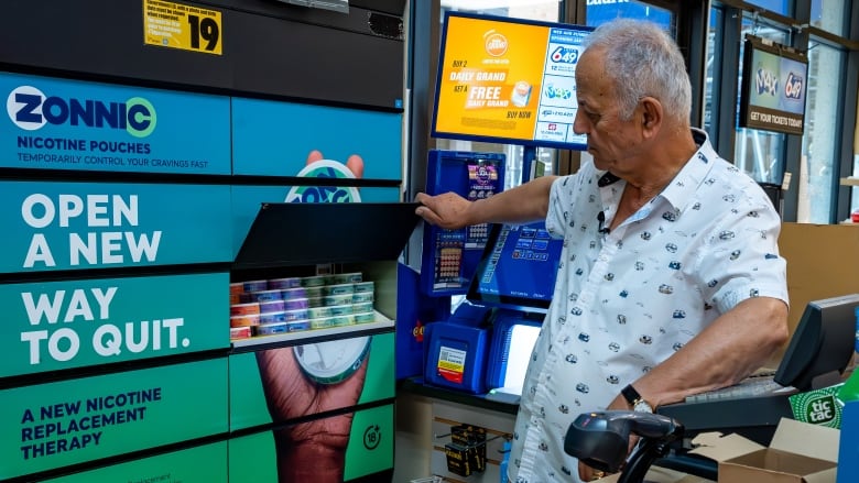 John Zyadh, owner of J.J.'s Market in downtown Ottawa, stands in front of shelves stocking Zonnic nicotine pouches.