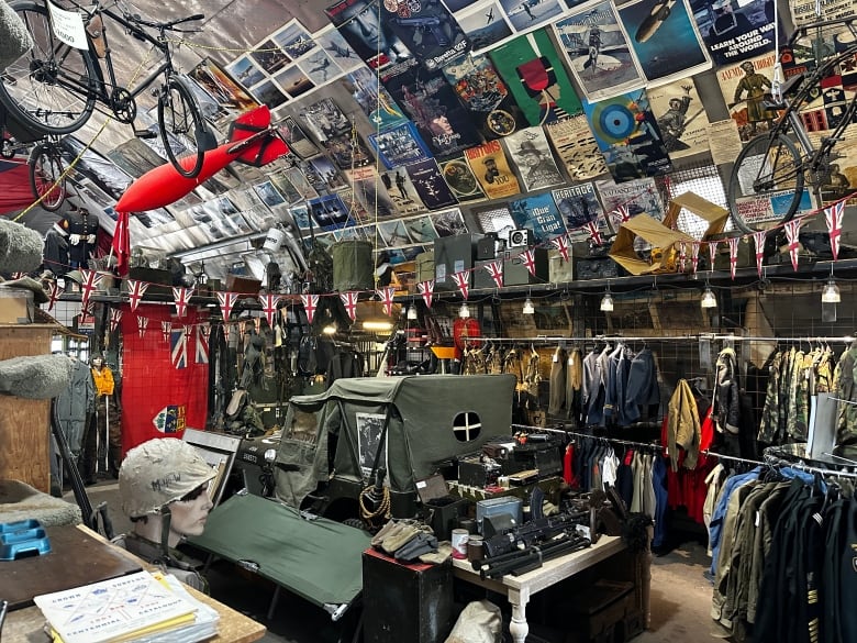 An assortment of colourful posters, shirts and other items line the walls and shelves of a store.