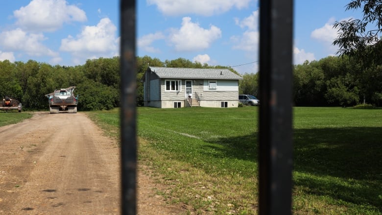 A house stands behind a fence