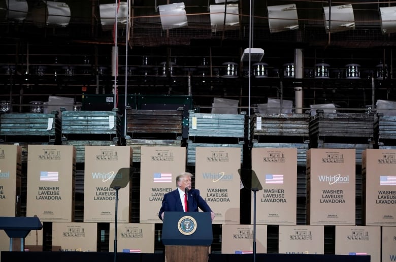 Trump in front of big boxes