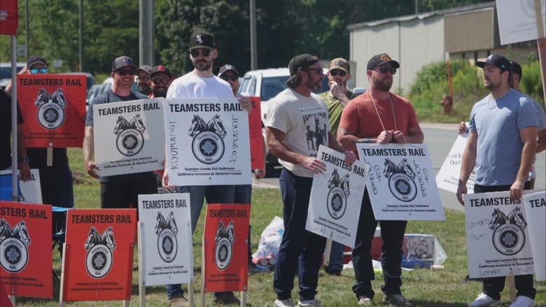 A group of men holding signs.