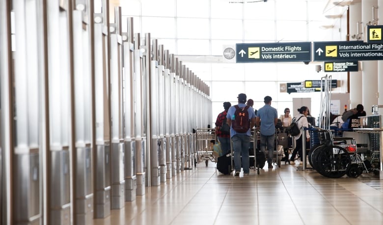 Passengers and signage at Winnipeg airport.