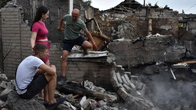 A couple sit in front of their house, which was destroyed by a Russian strike in Zaporizhzhia, Ukraine, on Tuesday.