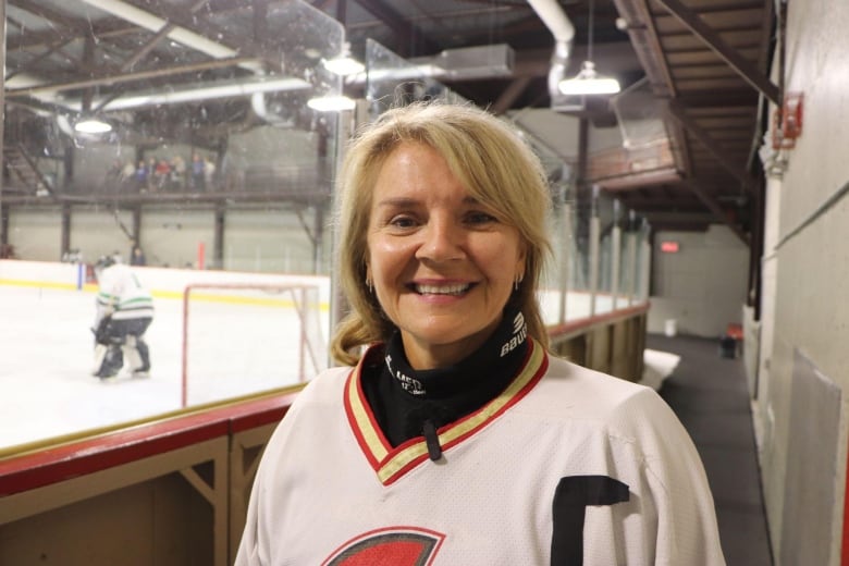 A woman smiles in a hockey jersey