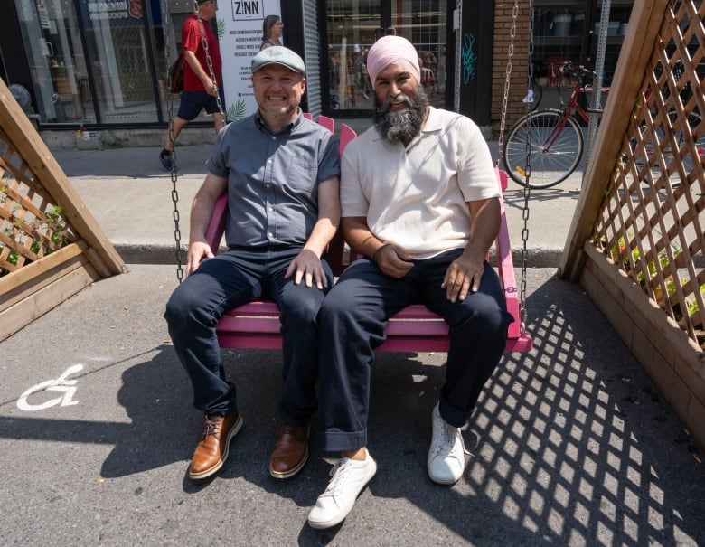 NDP leader Jagmeet Singh sits in a swing chair with candidate Craig Sauve Monday, July 29, 2024  in Montreal. A federal by-election will be held in the riding of Lasalle-Emard-Verdun Sept. 16, 2024.