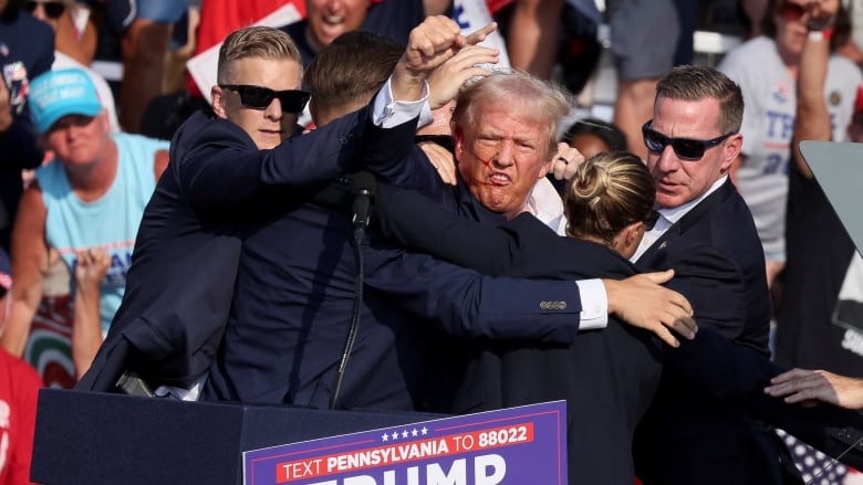 Former U.S. President Donald Trump is seen after he was shot in the right ear during a campaign rally.