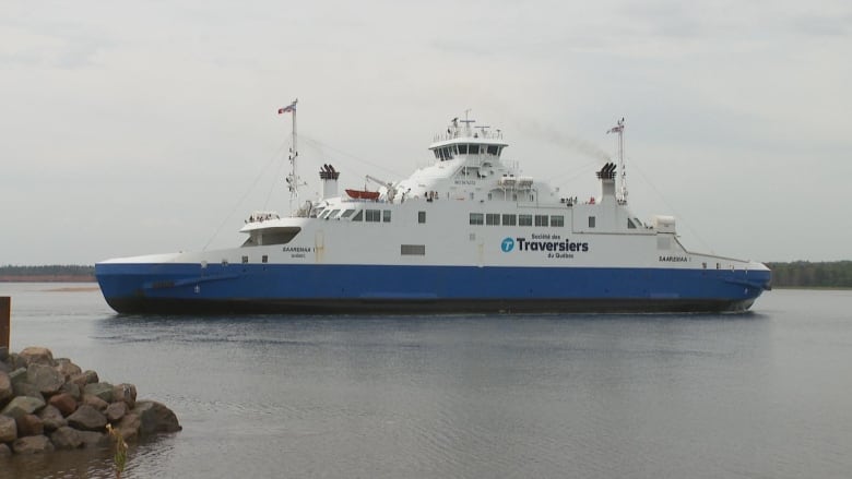 MV Saaremaa on the water with rock pier in foreground.