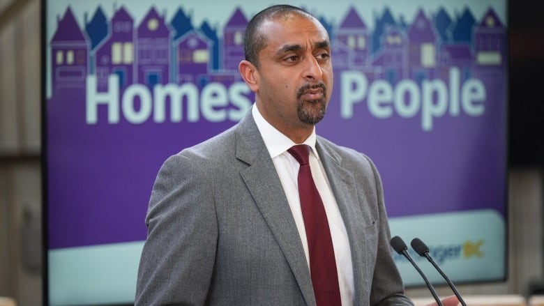 A man speaks at a podium.