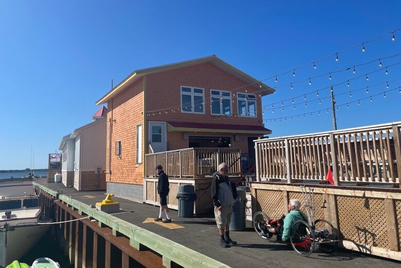 a bright orange building and a wooden deck on a wharf