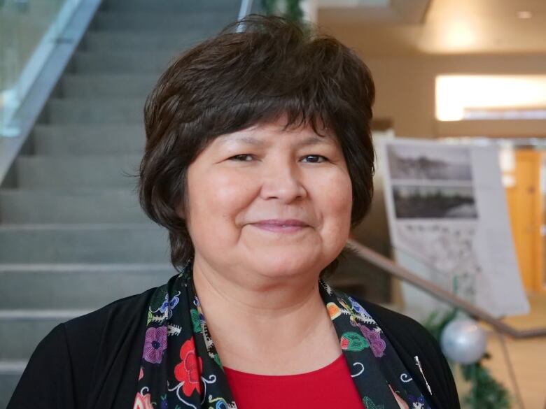 A woman with short brown hair smiles at the camera 