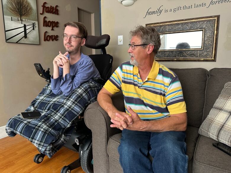 A man in a wheelchair talks with his father.