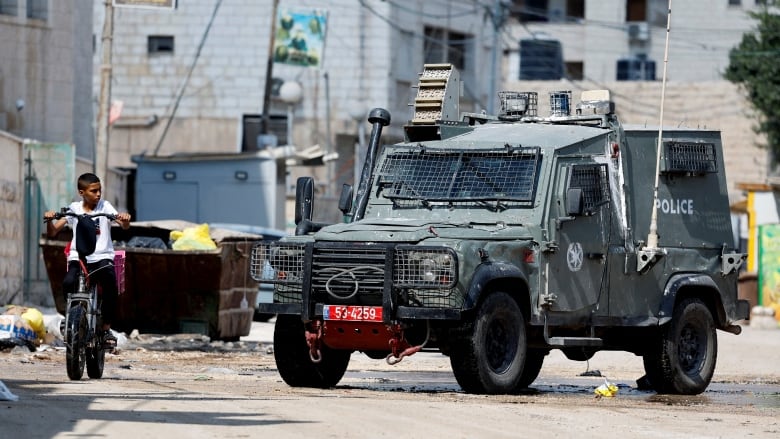 A boy rides a bicycle during an Israeli raid in Jenin, in the Israeli-occupied West Bank, August 30, 2024. 