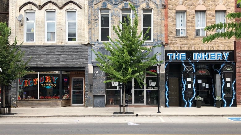 A view of the street where two tattoo shops are visible. 