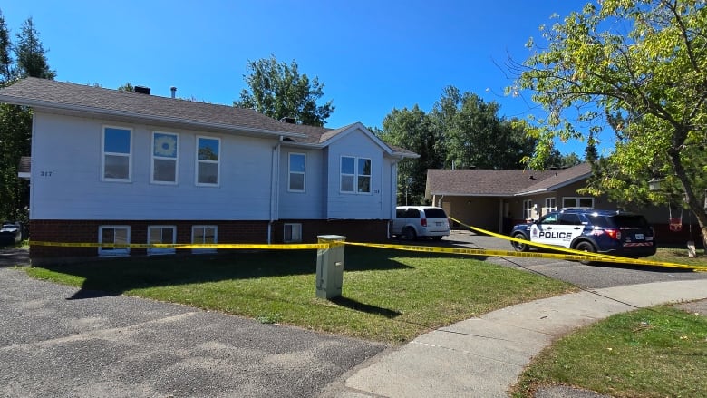 A house with police tape around it.