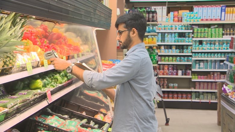 Family Foods owner, Kishan Zalawadia scanning produce in his store.