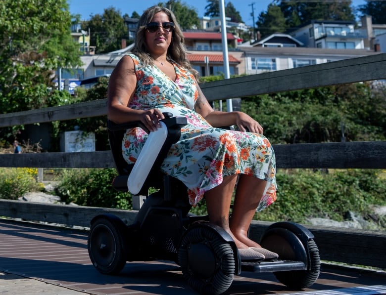 A woman in a floral dress in a wheelchair