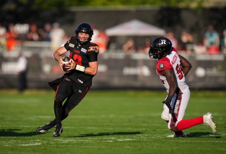 Two players from opposing team in the football field.