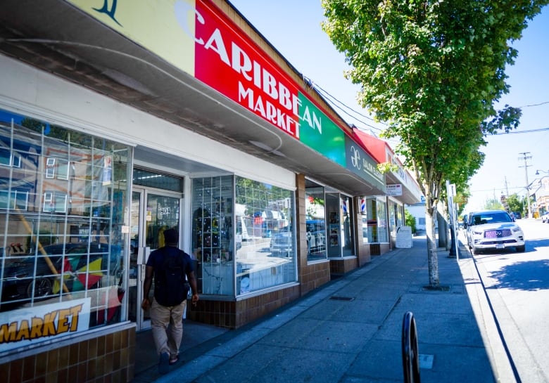 Businesses are pictured on 12th Street including a yellow, red, and green sign says Caribbean Market and a black and gold sign of Salon Elegant.