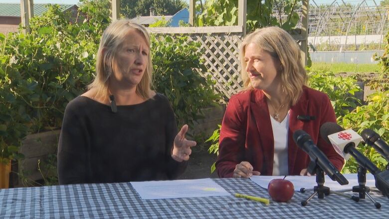 Two blond women sitting next to each other at a table