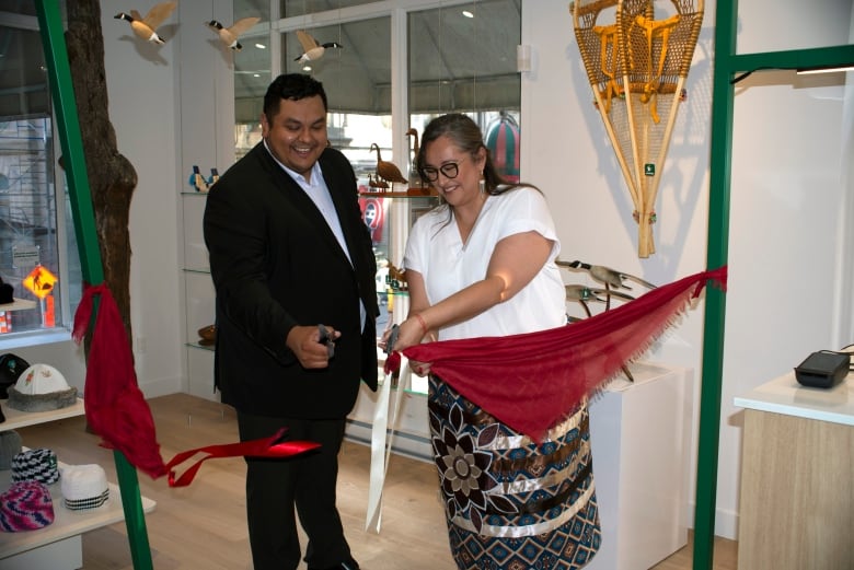 A man and a woman cut ribbon for grand opening for Wachiya store. 