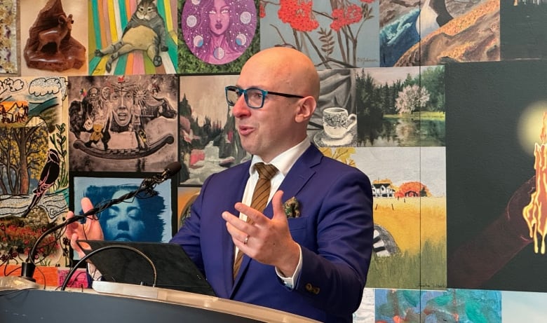 In a blue suit, Andrew Knack gestures with his hands to media and fellow colleagues as he announces he will not seek re-election in the 2025 election. 