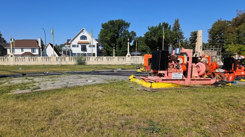 An orange water pump in a grassy park