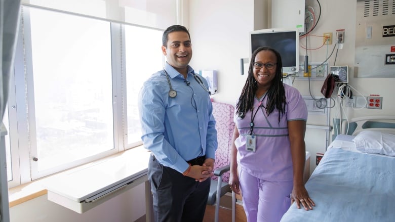 Unity Health Toronto clinician-scientist Dr. Amol Verma (left) stands with Shirley Bell, the clinical nurse educator for St. Michael's Hospital's general medicine program (right) inside a patient room.