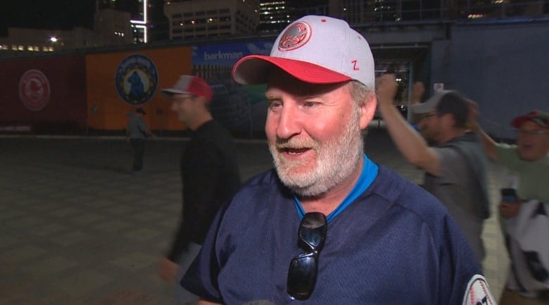 A man in a baseball hat and white beard