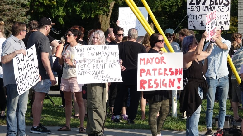 Kingston residents protest on street with signs calling on the mayor to resign 