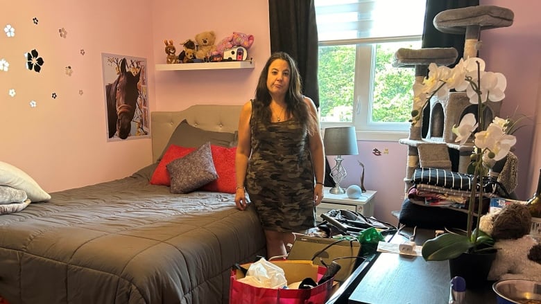 A woman standing in a room with boxes of belongings.