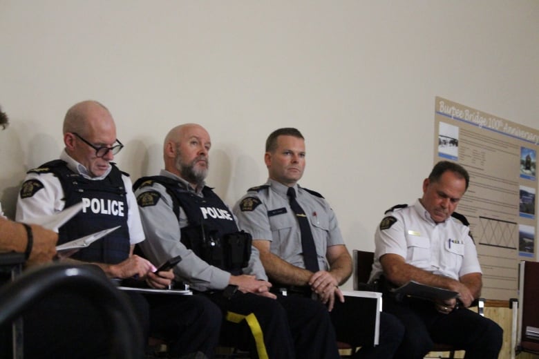 RCMP officers sit alongside each other during a meeting.