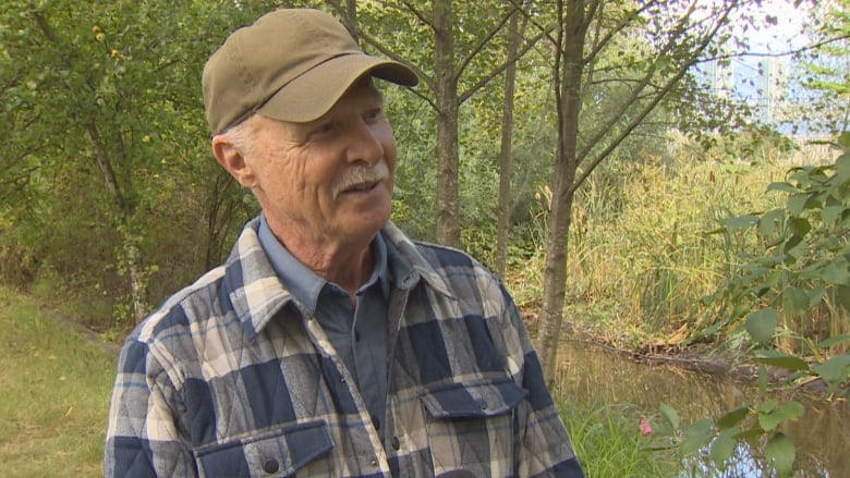 A man in a flannel and a baseball cap.  