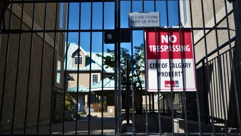 A black metal gate with a sign that reads NO TRESPASSING City of Calgary Property