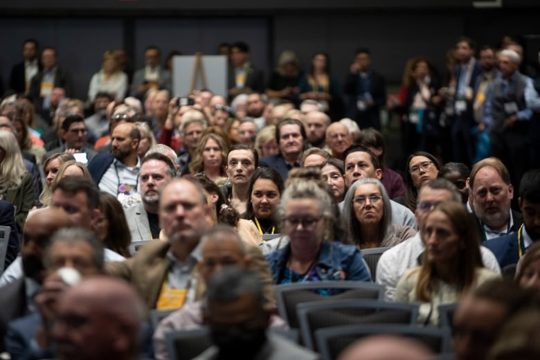 A crowd of people seated together in a convention hall