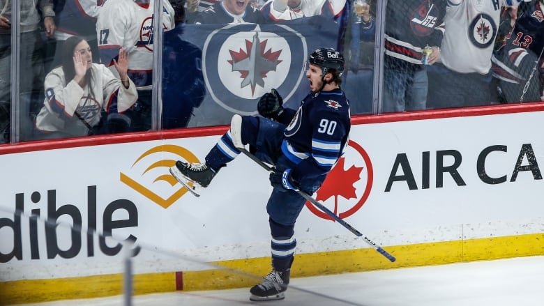 A hockey player on the ice cheers.