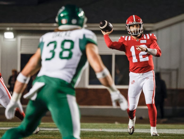 calgary quarterback is throwing the ball and a saskatchewan player is standing in the frame