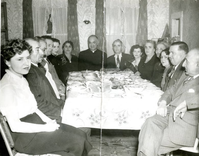 Black and white photo of group seated around a long table