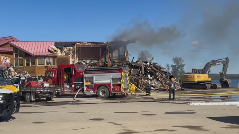 Firetruck and firefighters outside a building that was destroyed by fire