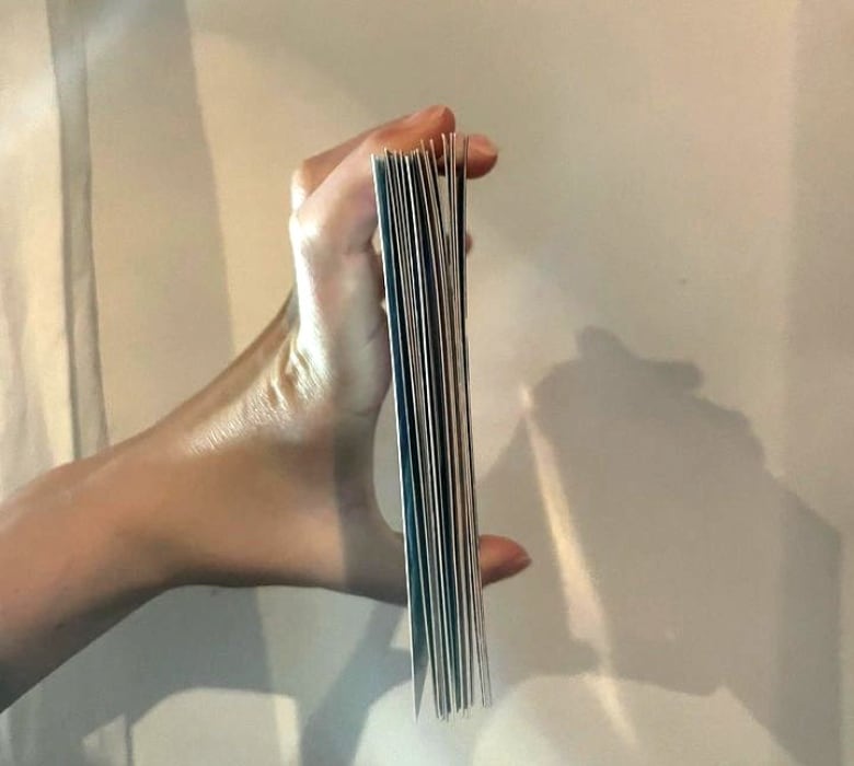 Hand holding a stack of postcards