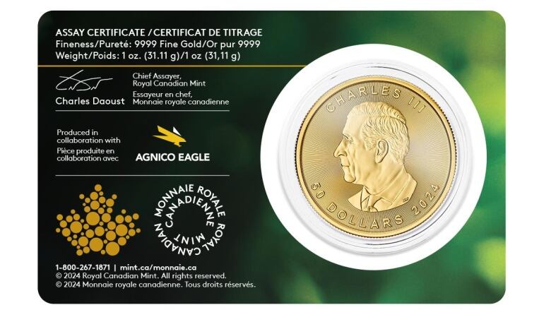 A gold coin with a side profile of a man with a green information sheet next to it.