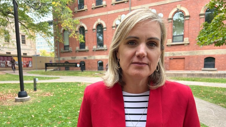 Woman with red blazer over striped shirt.