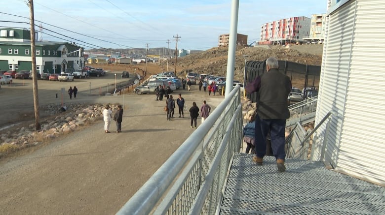 People leaving a courthouse and spread out in a parking lot