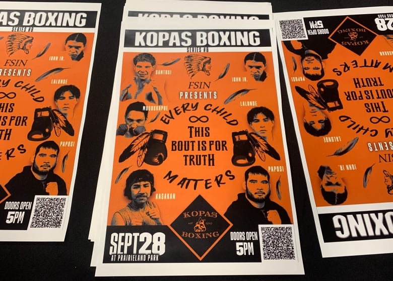 Orange posters advertising a boxing event in Saskatoon.