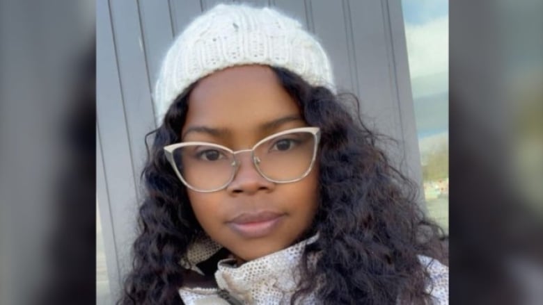 A Black woman with glasses wearing a tuque.