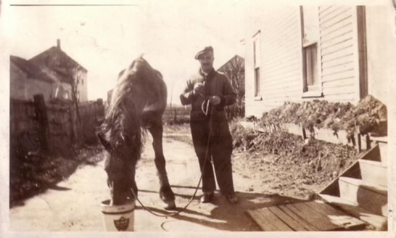 Mike Mansour, seen here with a horse, stands outside of a home in this archival photo from 1928.