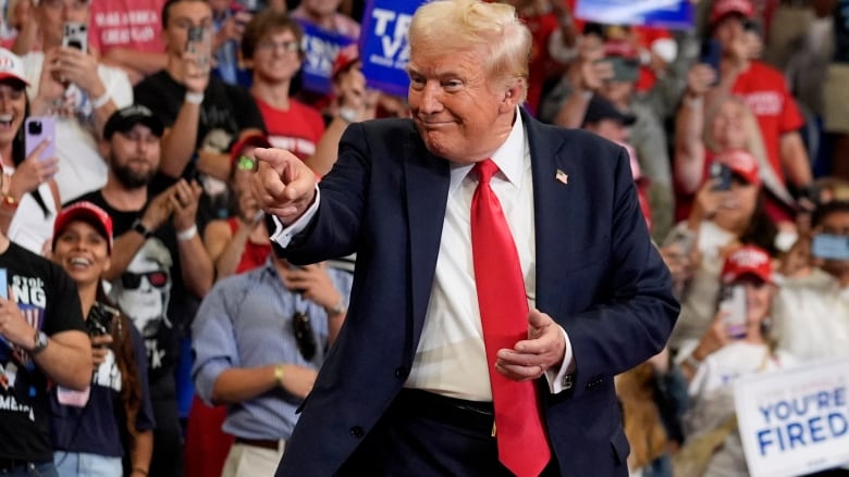 Trump points and smiles from stage