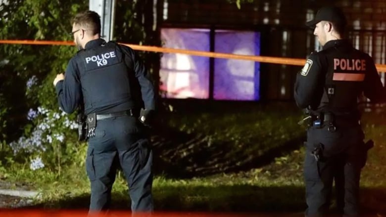 Two police officers standing at crime scene at night