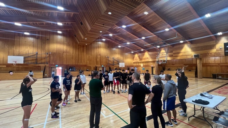 kids gather in a gym with coaches