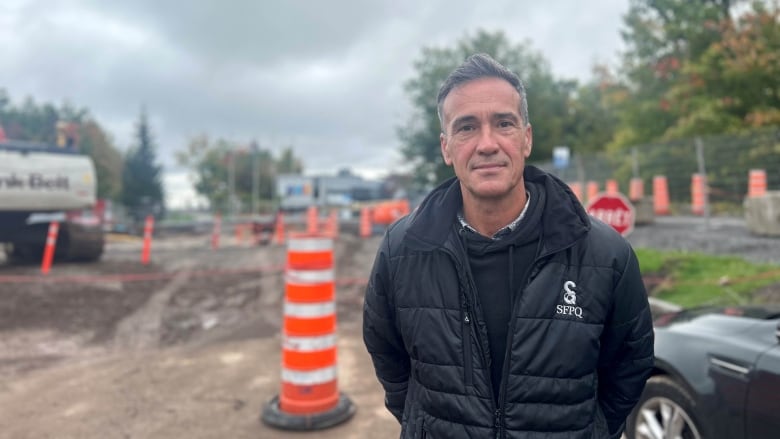 A man standing before a construction site. 